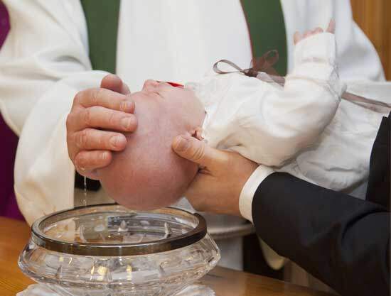 Infant baptism A priest sprinkling water on a baby's head during infant baptism