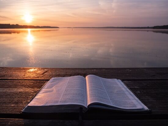 bible opened and sunset As the world feels like it's getting darker, the Bible opens to us the light of God's love and sin's darkness.