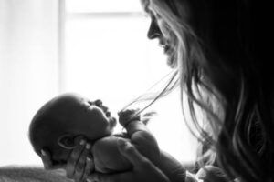 Mother and child A woman holding a baby and looking into its face.