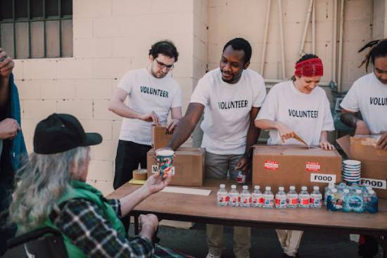 Volunteer donating food A group of volunteers hands out food and water, showing an example of mission projects.