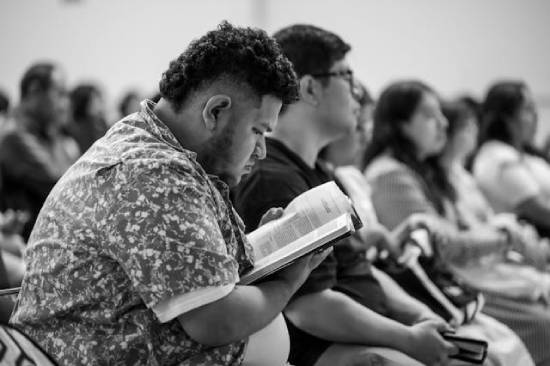 Man reading Bible A man looks at his Bible during a sermon, highlighting how Sabbath school is a time to study God's Word.
