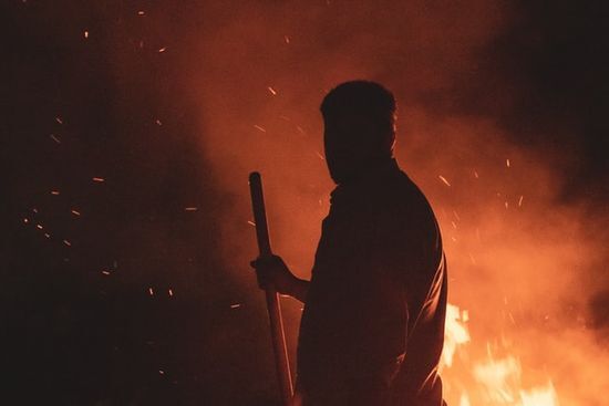 A shepherd standing by a blazing fire, representing Moses standing next to the burning bush