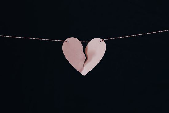 broken heart Paper heart in pink torn in two, tied to a rope, as we learn how sin is a failure to love God and love others.