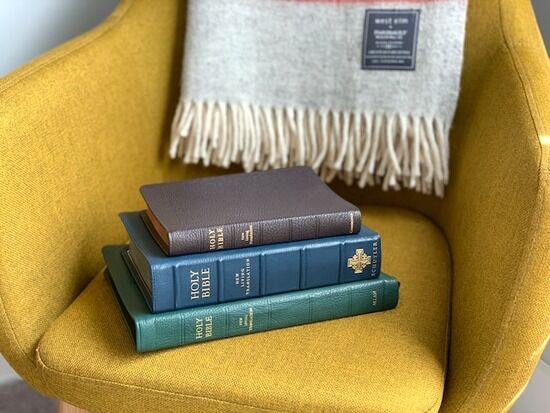 three Bible translations stacked on top of a chair Many have a stack of different Bible translations, which can be useful when studying Scripture.