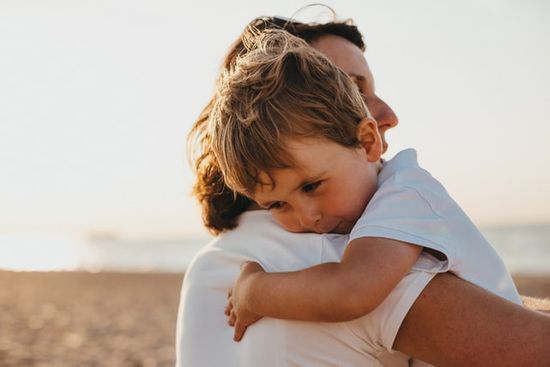 Child held by his parent A child being held by his parent, representing a secure relationship