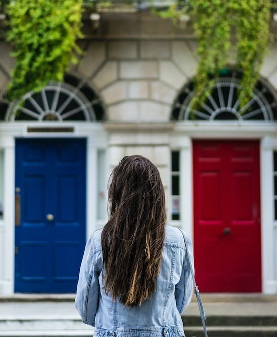 Woman standing before a blue door and a red door A woman standing before a blue door and a red door, exercising God's gift to human beings of freedom of choice