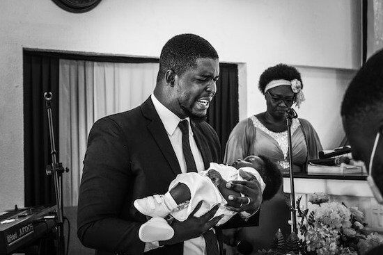 Pastor Dedicating Baby An Adventist pastor holding a baby during a baby dedication ceremony