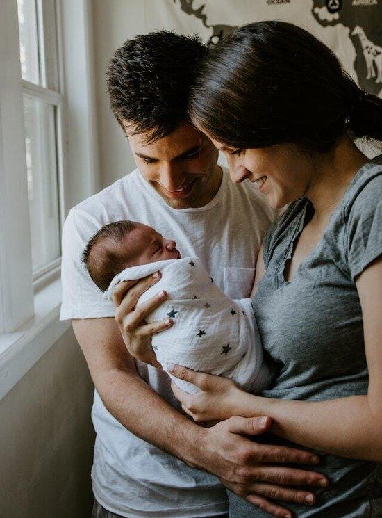 Parents Holding Baby Christian parents holding their baby and rejoicing in their child's life