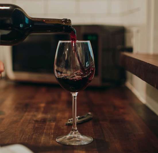Red wine pouring into a glass A bottle pouring red wind into a goblet