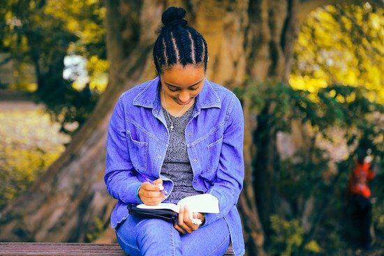 Girl Reading Bible Outside A young girl sitting outside and reading the Bible