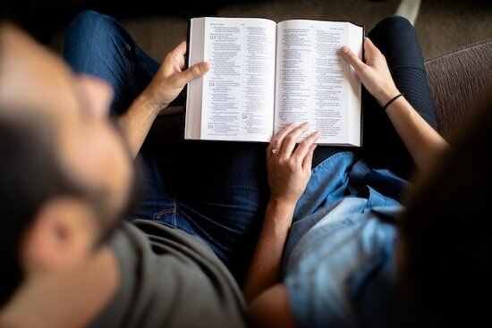 Couple Reading Bible A couple holds an open Bible so they can read the Word of God together.