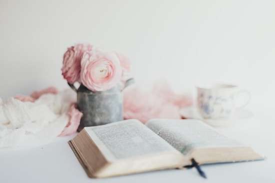 Open Bible An open Bible on a desk with flowers and a mug