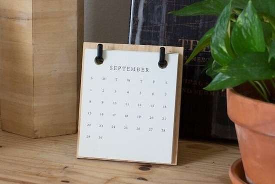 Calendar on Shelf A calendar for the month of September resting on a wooden desk.