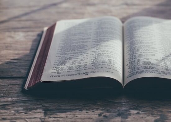 Open Bible on Old Wood A Bible open on a wooden table