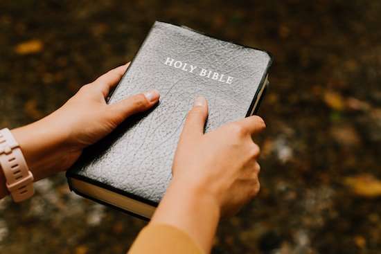 Woman Holding Bible A woman holding onto a Bible