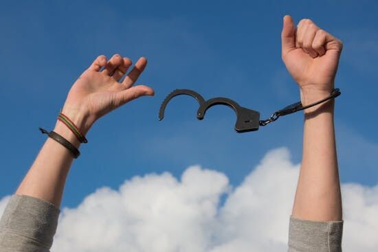 a man with open handcuffs Hands breaking free from handcuffs