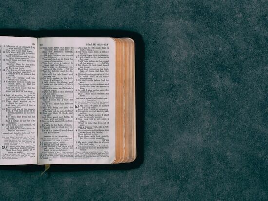 Open Bible on Green Table An open Bible on a green table