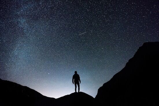 Sky full of stars A man on a mountain under a sky full of stars