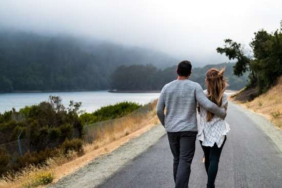 Couple walking together A couple walking along a road with the man's arm around the woman