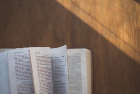 Fanned open Bible to Matthew and Luke Bible pages flipping open to the Gospel accounts of Jesus' baptism
