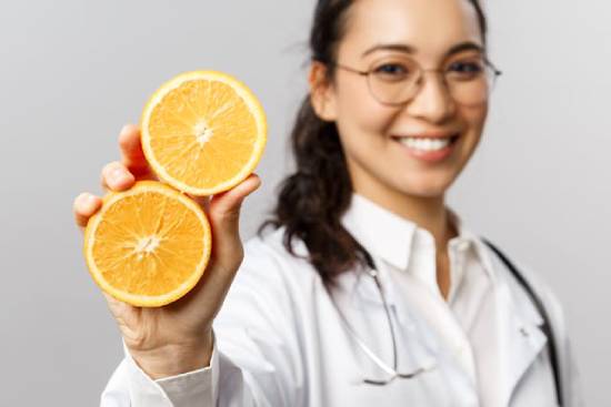 A doctor holding up an orange that's been split in half