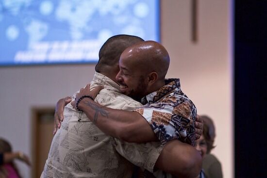 Forgiveness Two men hugging together as they reconcile in their friendship by apologizing and forgiving each other through Holy Spirit.