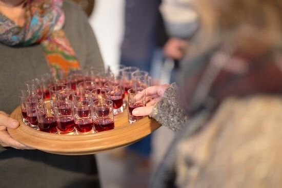 An Adventist church member holding a tray with small cups of grape juice for Communion