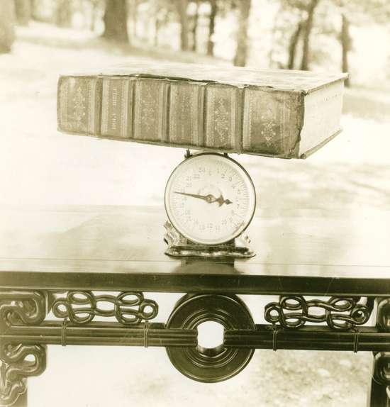 Large Bible on Scale A scale weighs a heavy, family Bible.