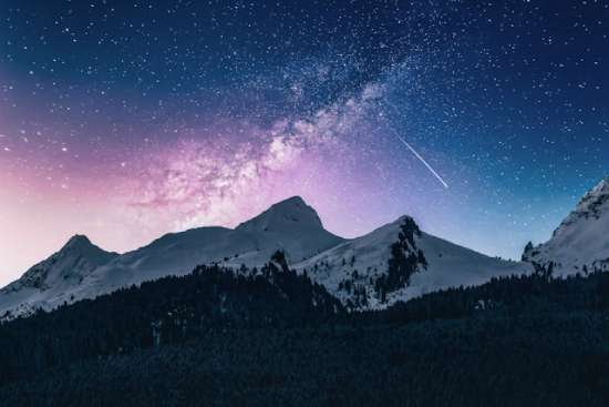 Tall mountains under a starry night sky, illustrating how outer space is sometimes called "heaven."