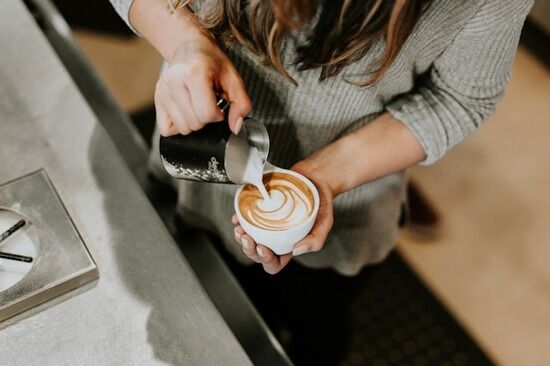 Barista preparing a latte in a coffee shop Going to a coffee shop is one way to reward yourself. It can feel special when watching a barista prepare a latte.