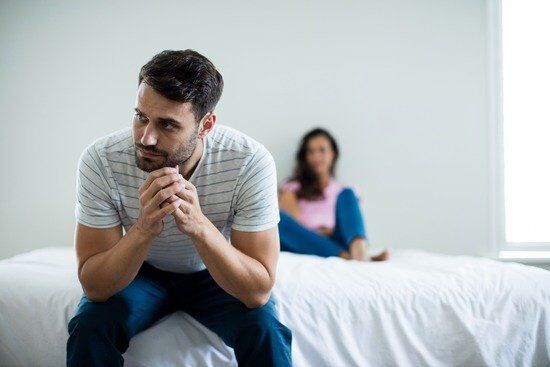 Man Frustrated at Wife A man facing away from his wife in frustration over an argument