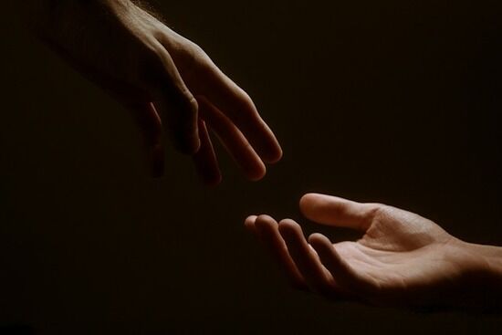 Two Hands Reaching Love A hand reaching out in love to grab another hand