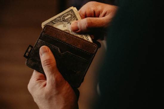 Man Taking Money out of his Wallet A man takes a dollar from his wallet.