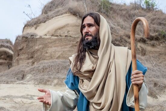 Jesus holding a shepherd's staff in one hand and reaching out with the other hand