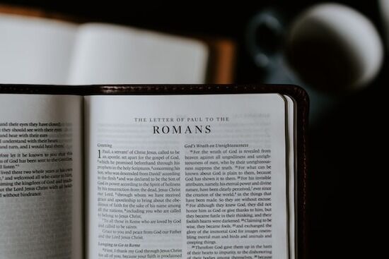 A Bible is opened to Romans.