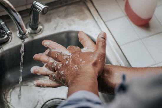 A person washes their hands in a sink, illustrating how personal hygiene was recognized as an essential part of health in Ellen White's day.