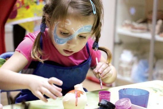 Girl Painting at VBS A little girl painting a small sculpture at a vacation Bible school