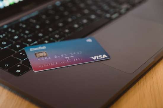 Credit Card on Computer A Visa credit card sits on top of a computer.