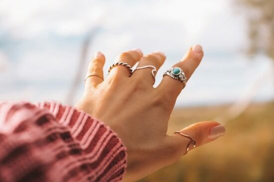Rings on Hand A young person's hand has simple rings on each of the five fingers.