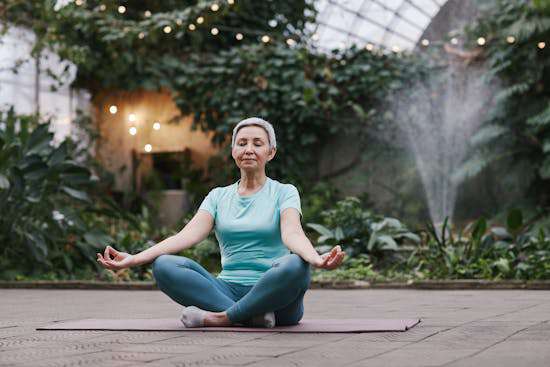 Woman Meditating Spiritual Deception A woman meditating with folded legs and outstretched arms.