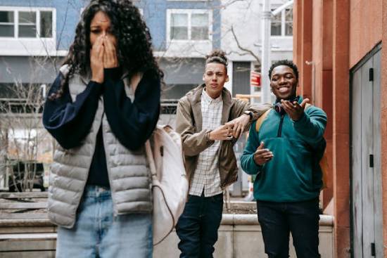 Two young men tease a young woman, making her weep and walk away. And it represents the persecution Jesus received from among His own people—like the Jewish leaders.