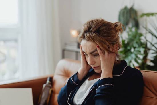A woman holds her head like she's stressed out, which demonstrates how it can feel to wrestle with doubts.