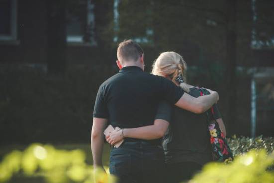 Couple embracing as they forgive each other A young couple walks together with their arms around each other