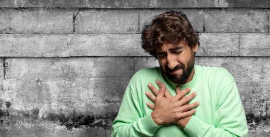 A man clasps his hands over his heart, seemingly in anguish from his battle with sin.