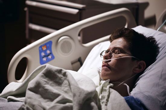 A sick man An ill man lies asleep in a hospital bed.