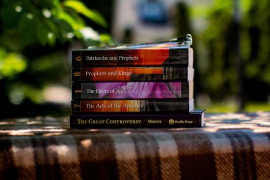 Ellen White Books A stack of books from the Conflict of the Ages series written by Ellen White, Patriarchs and Prophets, Prophets and Kings, the Desire of Ages, the Acts of the Apostles, and the Great Controversy