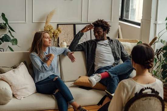 Interfaith coupled being counseled An interfaith couple sitting on a couch together during a counseling session