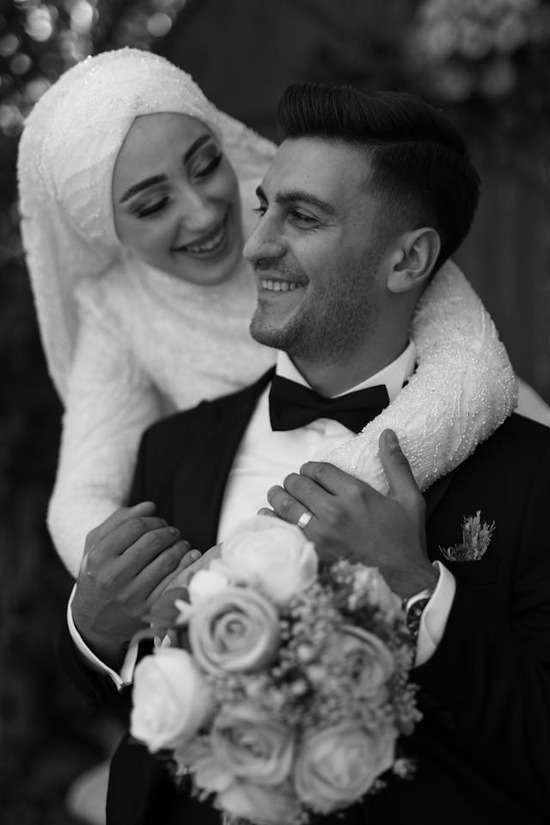 An interfaith marriage A Muslim woman in white wedding attire with her arms around her husband, representing an interfaith marriage