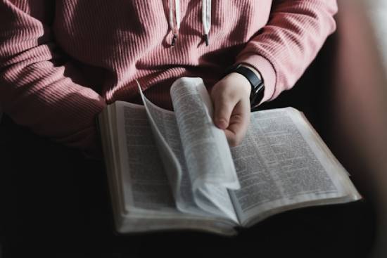 Person Turning the Pages of a Bible A person turning the pages of their Bible, illustrating the importance of letting the Bible guide us and be our authority for end-time prophecy.