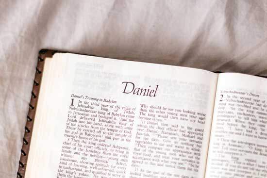 A Bible is open to the book of Daniel.